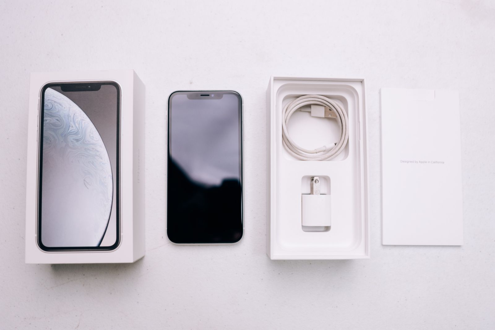 Smartphone con su caja y accesorios ordenados, mostrando su estado