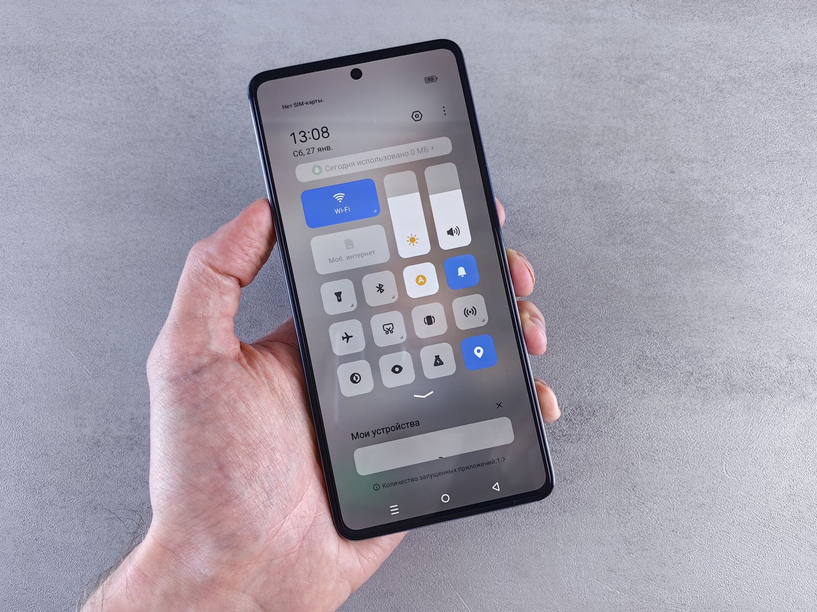 Mano sosteniendo un iPhone con la pantalla de ajustes abierta